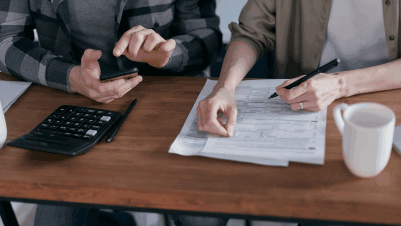 Two People Doing Paperwork and Computing Taxes
